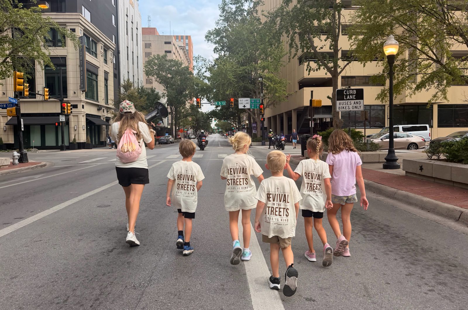Children in Revival in the Streets shirts walking down a downtown Fort Worth street during the march